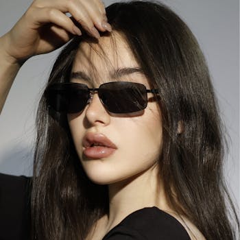 Chic portrait of a woman wearing sunglasses, radiating modern fashion elegance.